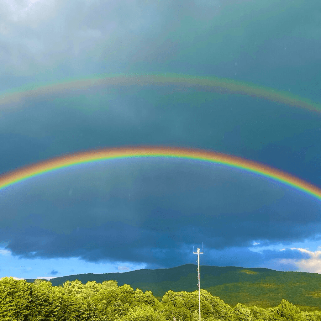 Double rainbow over White Mountains scenery during a warm-weather weekend