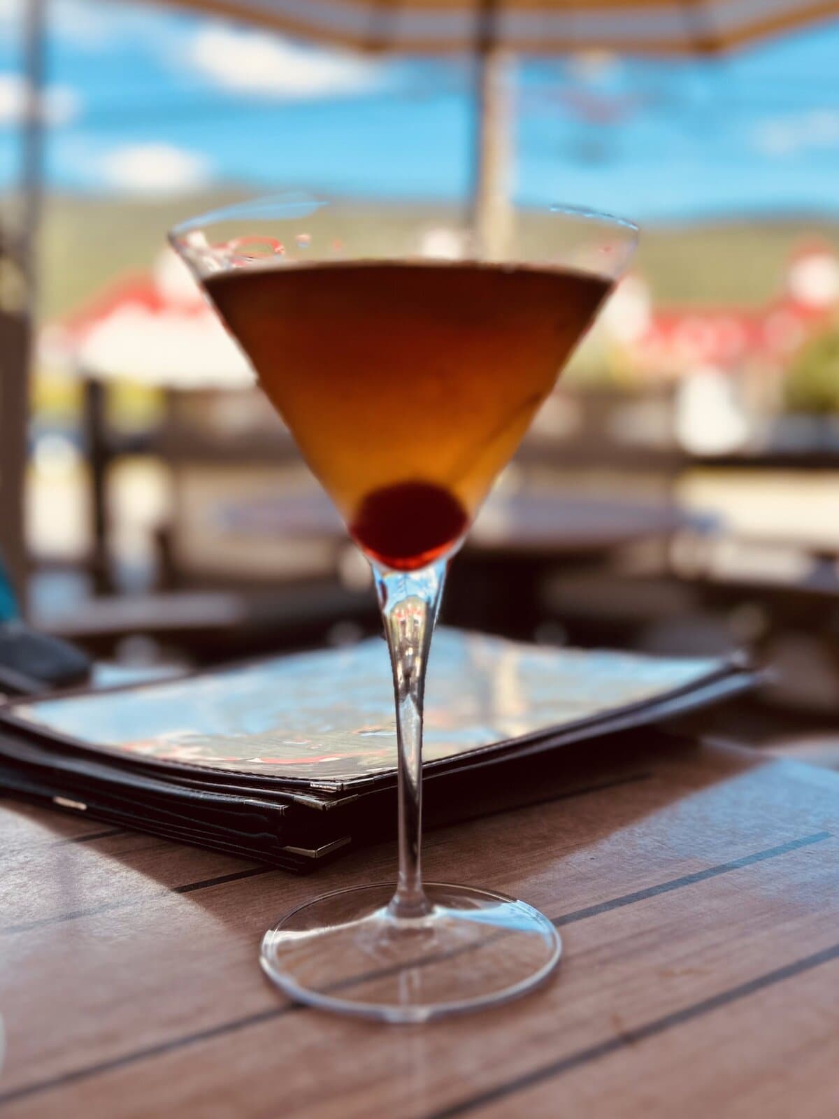 Craft cocktail on an outdoor restaurant patio with mountain views in North Conway, New Hampshire