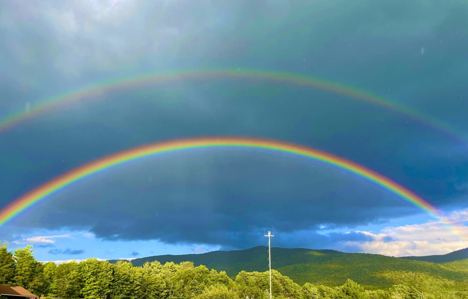 Double rainbow arching over the green White Mountains